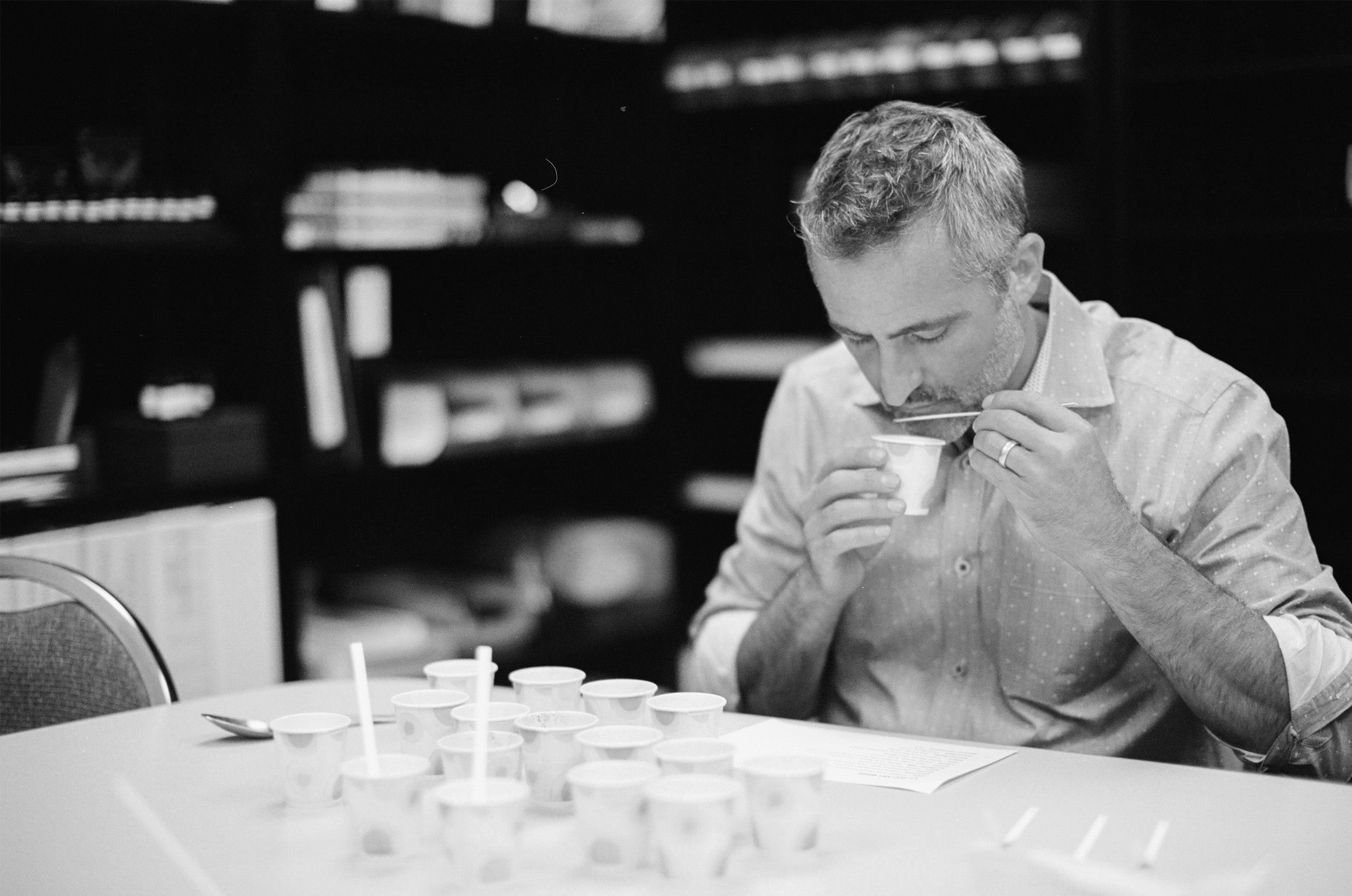 Votivo president smelling fragrance oil in Votivo fragrance lab.