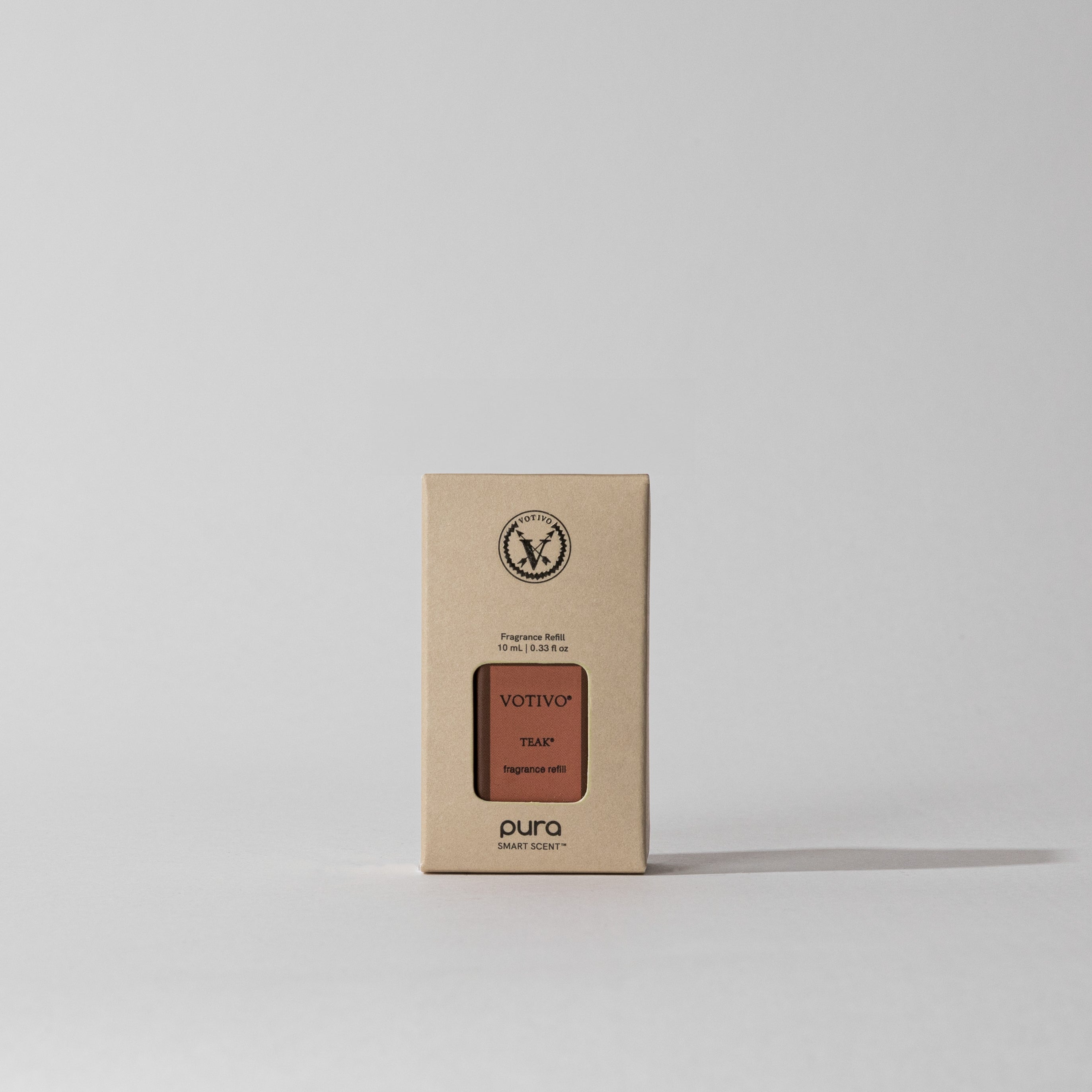 A Votivo Teak Pura + Votivo Smart Fragrance Refill box, featuring a woody scent, stands upright on a plain light background with a subtle shadow cast to the right.