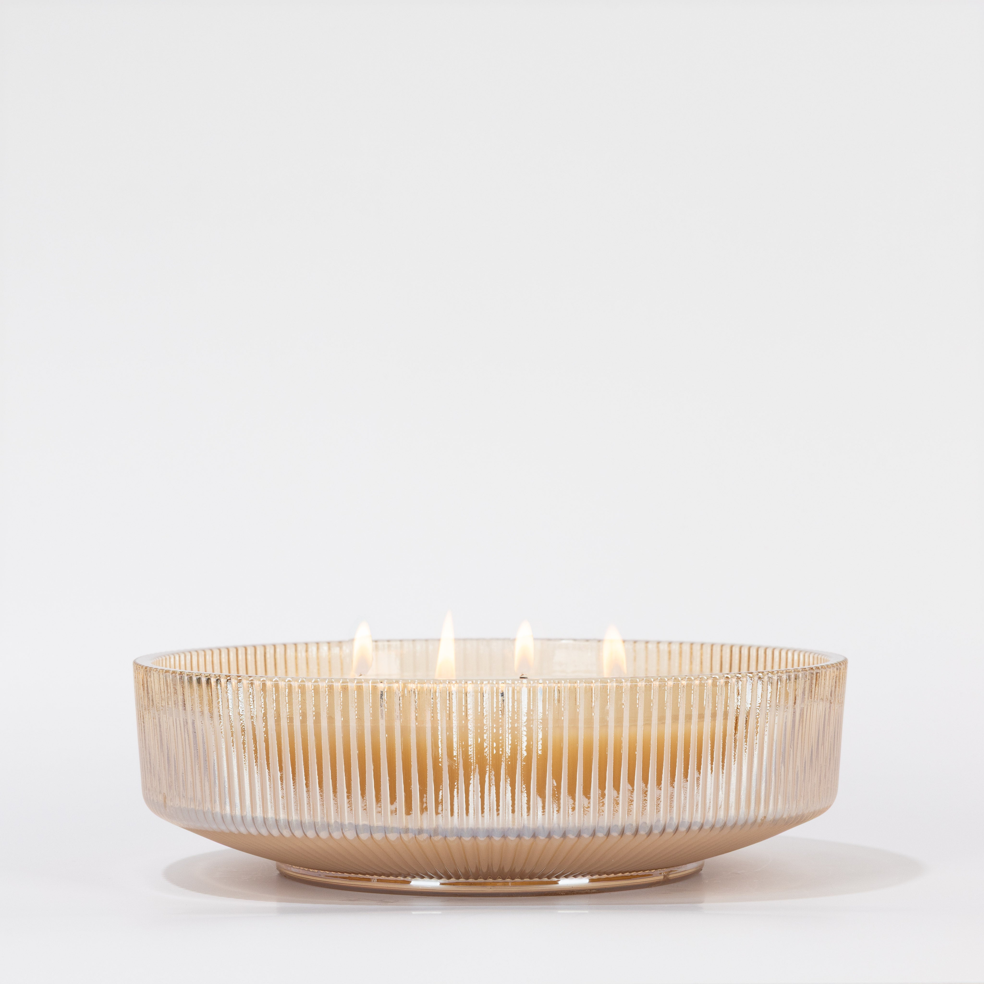 A round, ribbed glass bowl showcases the Votivo Velvet Rouge Holiday Multi-Wick Candle, made from soy blend wax with five evenly spaced flames, all set against a plain white backdrop.