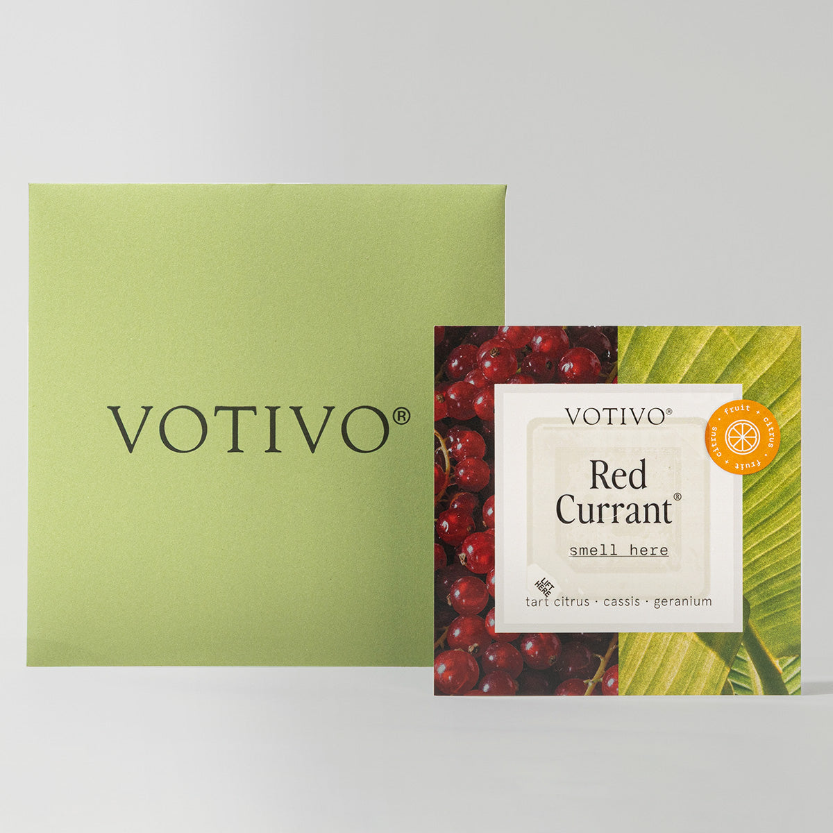 A green square Votivo box sits beside a Votivo Fragrance Sample Kit sachet labeled Red Currant, adorned with red currants and green leaves—perfect for discovering your signature scent of tart citrus, cassis, and geranium.