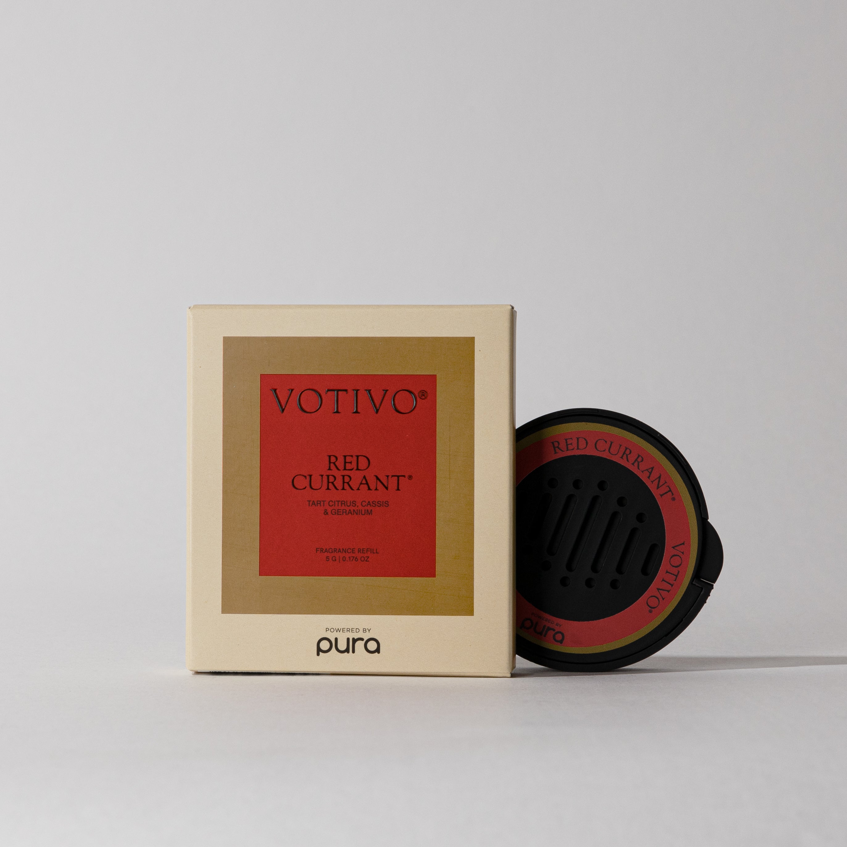 The Votivo Red Currant Pura Car Diffuser Cartridge, in beige packaging with a red label, sits beside its branded refill—ideal for adding long-lasting Red Currant fragrance to your car.