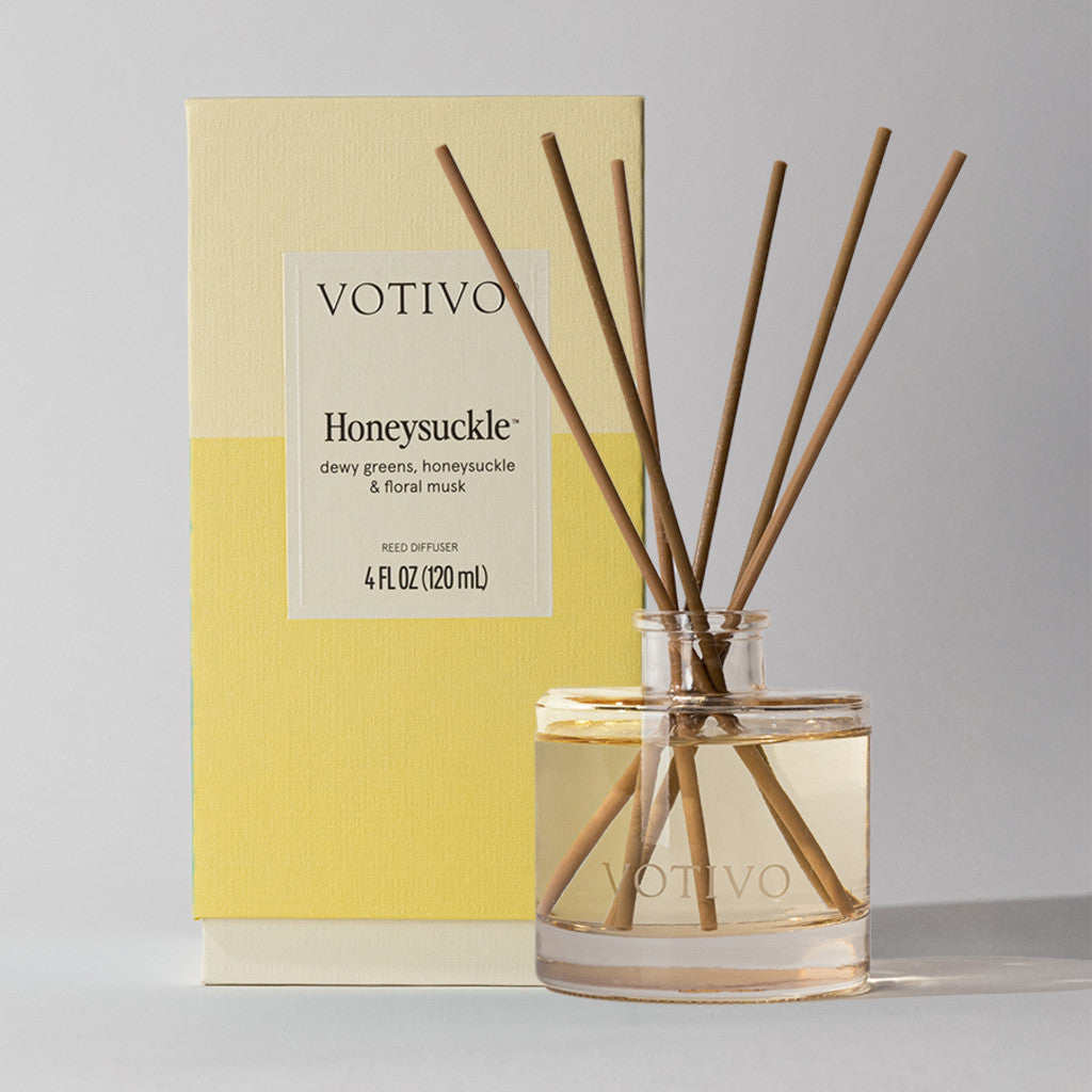 A Votivo Honeysuckle Reed Diffuser with fiber reeds stands before its yellow and cream box, labeled with the scent Honeysuckle and size 4 fl oz (120 ml).