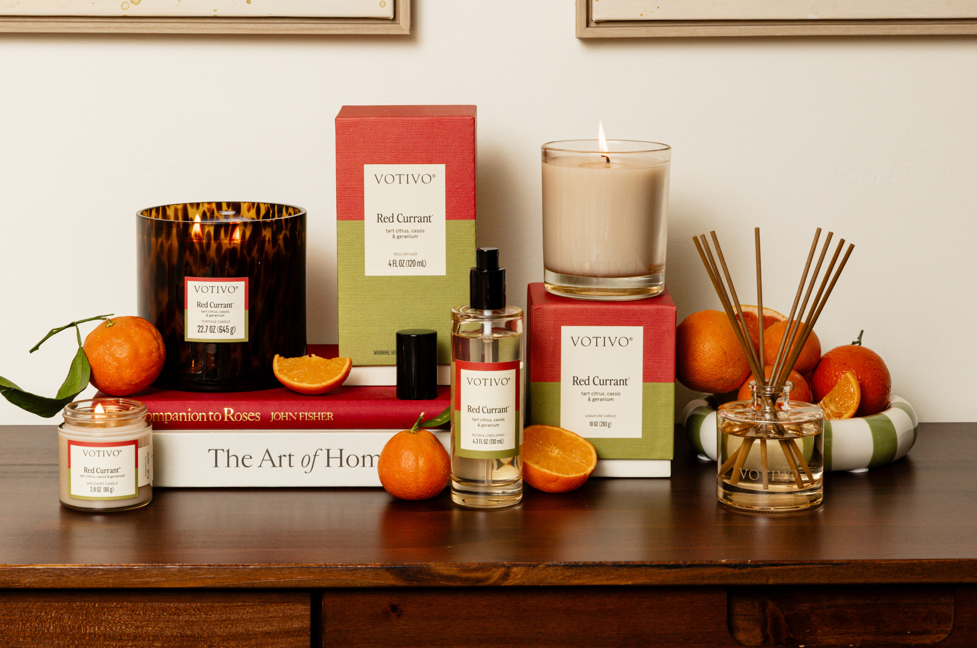 Red Currant home fragrance collection group photo with oranges and other bright accessories that match the vibrant, citrus fragrance.