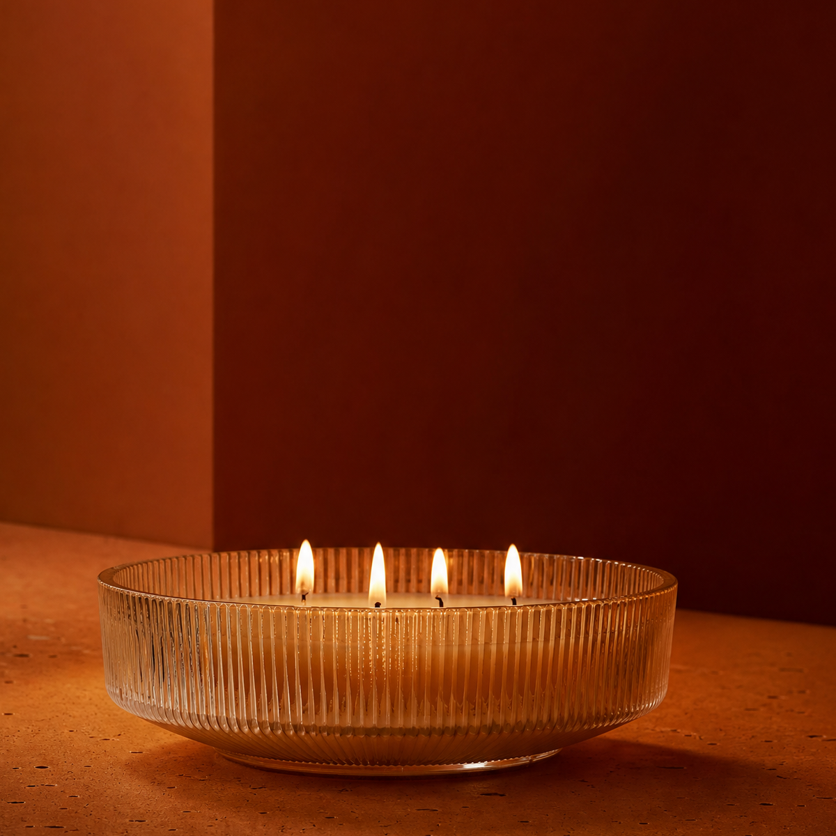 4 Wick Lit Candle on Orange Terra cotta surface 