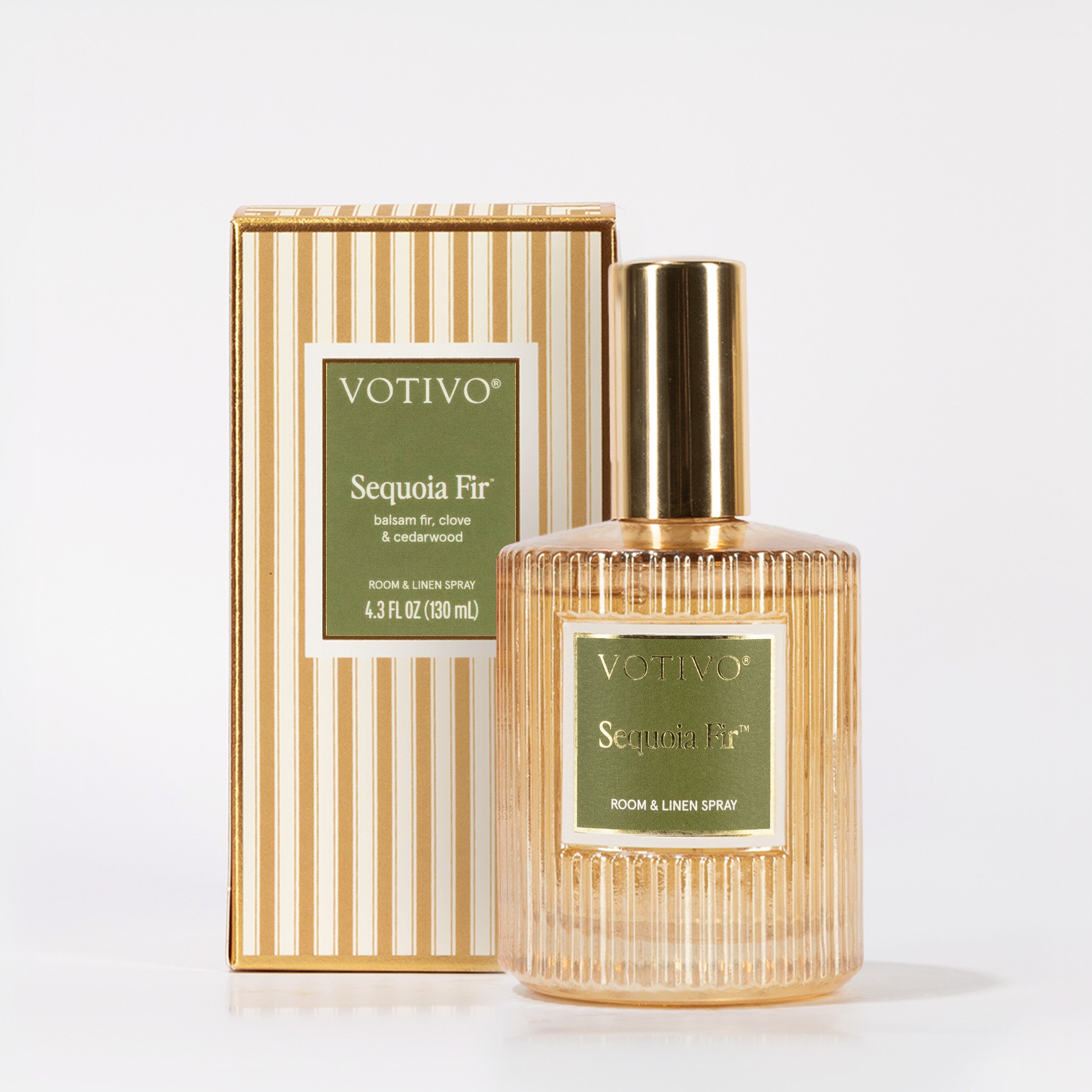 A gold-capped, textured glass bottle of Votivo Sequoia Fir Room & Linen Spray with a green label is displayed in front of its matching striped box. This fabric safe spray features the fresh scent of Sequoia Fir.