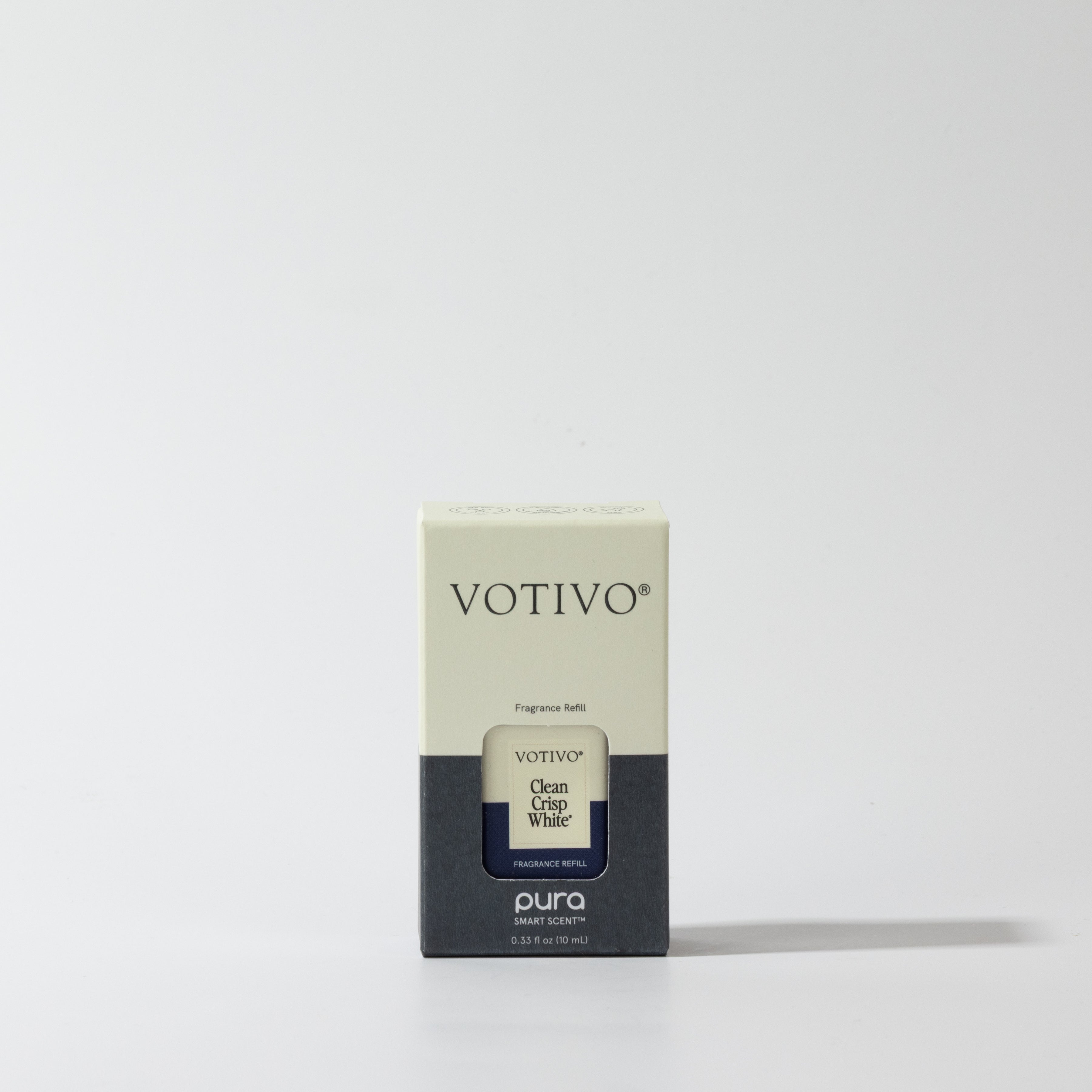 A Votivo Clean Crisp White Pura Refill Vial sits centered against a plain white background. Designed for use with a smart fragrance diffuser and the Pura app, the box features off-white, gray, and blue accents.