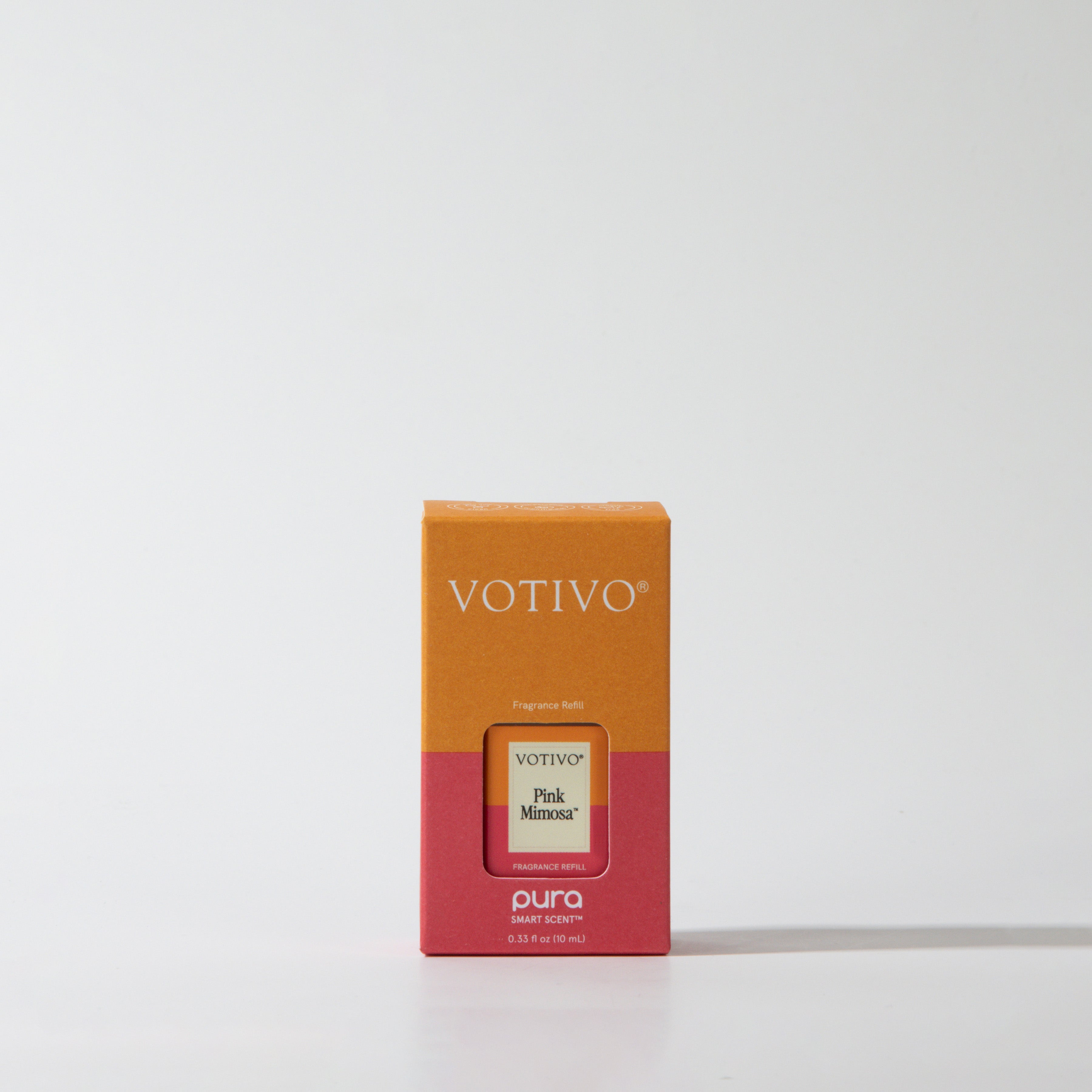 The Votivo Pink Mimosa Pura + Votivo Fragrance Refill Vial, made for Smart Fragrance Diffusers and the Pura app, comes in packaging with orange and pink blocks and white text, displayed on a white background.